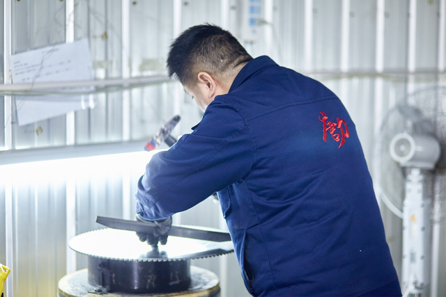 worker inspecting band saw blade12