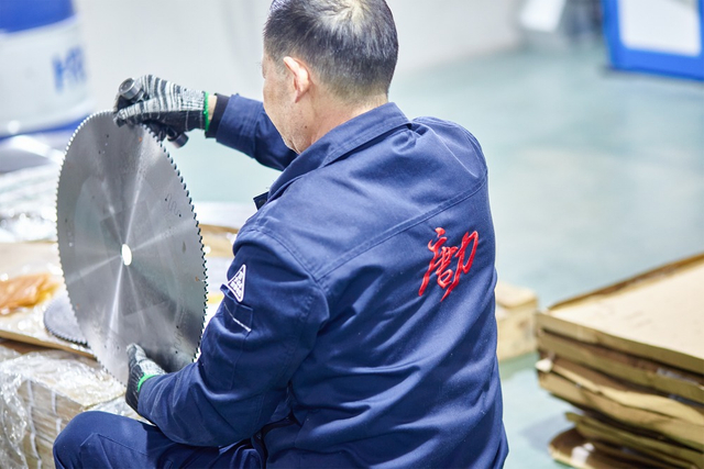 worker inspecting band saw blade11