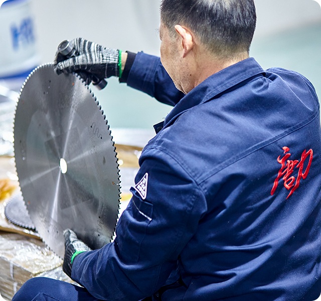 worker inspecting band saw blade